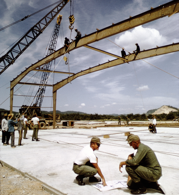 Soldiers on girders of a warehouse under construction